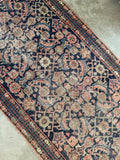 Full width view of antique Persian runner with faded navy field.