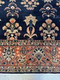 Close up of palmette motifs across navy ground Sarouk rug.