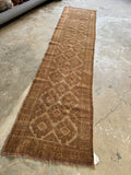 Neutral tribal runner with lattice pattern and graphic motifs.