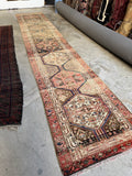 Antique hallway runner with lightened pastel dyes and tribal symbols.
