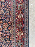 Low pile antique Persian Tabriz wool rug with rich terracotta red border bands.
