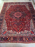 Large 1920s Persian Heriz rug with geometric tribal artistry and vegetable dyed wool.