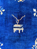 1930s vintage Chinese Peking rug close up detail of a stylized furniture motif against a saturated blue ground.