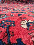 Antique Persian rug detail showing the intricate curvilinear botanical elements and soft wool weave.