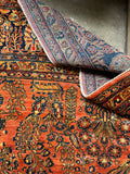 Oversized antique Persian Sarouk rug with radiant coral tones and old world wool.