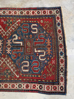 One end of Kazak rug with traditional tribal symbols.
