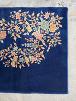 Pastel floral Art Deco Chinese rug against a navy blue ground.