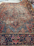 Highly decorative tribal motifs throughout worn antique Persian Heriz rug.