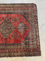 View of the other end with low pile texture with light scattered wear on rug surface.