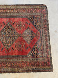 View of the other end with low pile texture with light scattered wear on rug surface.