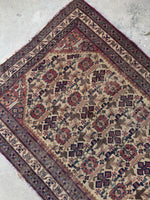 Small Afshar rug with diamond motifs and floral accents.