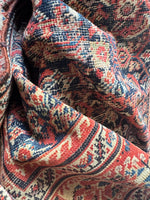 Vintage Persian rug with aged dyes and a low pile.