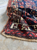 Low-pile vintage Persian rug with scattered wear and a stout, sturdy weave.