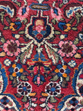Persian vintage rug detail showing luxurious wool texture and supple weave under hand.