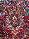 Close up of hand knotted Persian Dargazin runner with vegetable dyed wool and floral design.