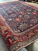 Diagonal view of Persian Heriz rug with a navy blue ground.