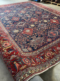 Diagonal view of Persian Heriz rug with a navy blue ground.