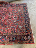 One end of antique Heriz rug with tribal motifs and colorful palette.