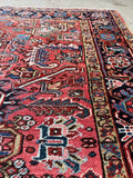 Persian Heriz rug with tribal motifs in red and blue tones.