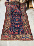Antique Persian Kurdish rug with navy field and camel border..