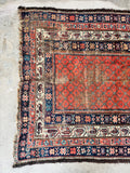 Authentic handwoven Persian rug showing natural vegetable dye color variations and distressed wool texture.