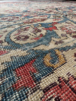 Close-up of a Persian Mahal rug main field with red, blue, and ivory colors.