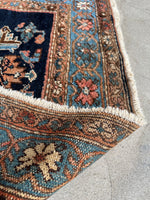 Underside view of a Persian Malayer rug framed with dainty floral chains.