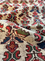 Floral and geometric elements on ivory ground of Persian rug.