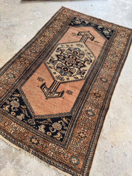 Handwoven Persian rug from the 1920s featuring whimsical fish and animal motifs.
