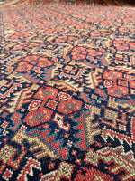 Detailed Persian rug from the 1920s showing floral and geometric motifs.