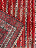 Authentic tribal Persian wool rug with floral chain borders and candy stripe artwork.