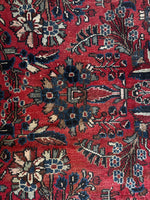 Bold floral motif on a dark brick red wool background.