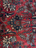 Bold floral motif on a dark brick red wool background.