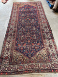 Long Persian rug with endless garden design and turtle motif border.