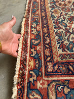 Persian rug featuring floral chain border and decorative motifs.