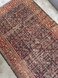 Worn areas of antique 1920s Persian rug showing authentic low pile character.