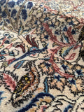 Persian rug with silk highlights that shimmer against ivory background.