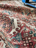 Antique Persian hallway runner with warm ivory border and geometric tribal motifs in earthy colors.