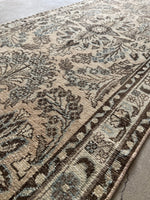 Antique runner rug with a light, subdued color palette.