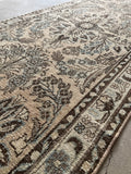 Antique runner rug with a light, subdued color palette.