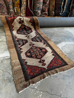 Brick red Persian runner with camel hair border.