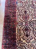 Ivory and navy Persian Sarouk rug detail shot of the midnight blue border with vibrant madder red accents.