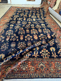 Antique Persian Mohajeran Sarouk rug with navy ground and all over floral design.