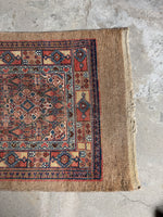 One end of Persian Seraband runner with red and blue borders and floral motifs.