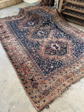 Antique Persian Shiraz rug with three medallions on a navy ground.