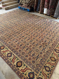 Diagonal angle of large Tabriz rug showing intricate navy and brick red motifs.