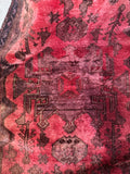 Center medallion detail on a 1970s Persian rug with graphic tribal style motifs.