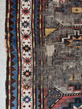 Vintage Caucasus Kazak rug with bold tribal drawing and worn wool texture.
