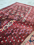 Yomut tribal rug demonstrating the dark moody color palette and authentic handmade construction.