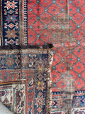 Antique Persian wool rug close-up detailing the hand-knotted weave and aged natural vegetable dye patina.